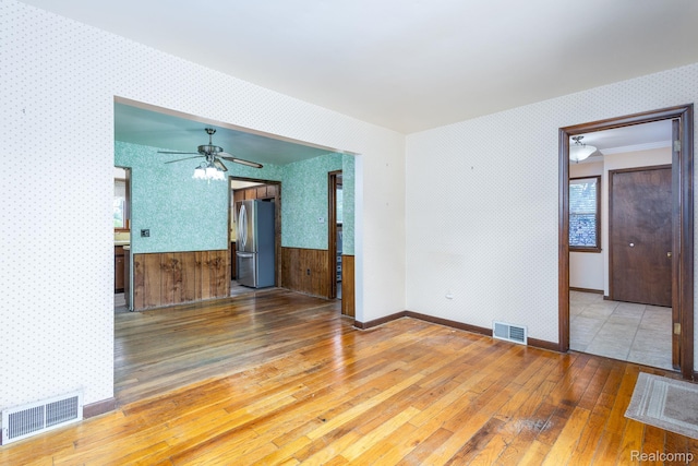 2500 Howe St, Shelby, MI 48317 - unfurnished room with wallpapered walls, hardwood / wood-style floors, ceiling fan, and a wainscoted wall