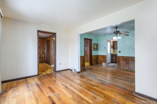 2500 Howe St, Shelby, MI 48317 - unfurnished living room with hardwood / wood-style flooring, wallpapered walls, and a ceiling fan