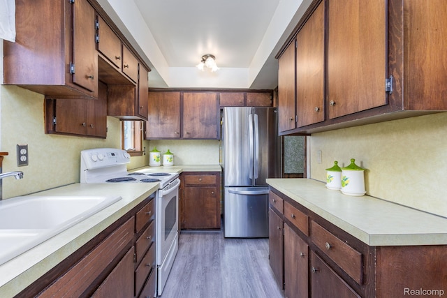 2500 Howe St, Shelby, MI 48317 - kitchen with freestanding refrigerator, white range with electric stovetop, light countertops, light wood finished floors, and a sink
