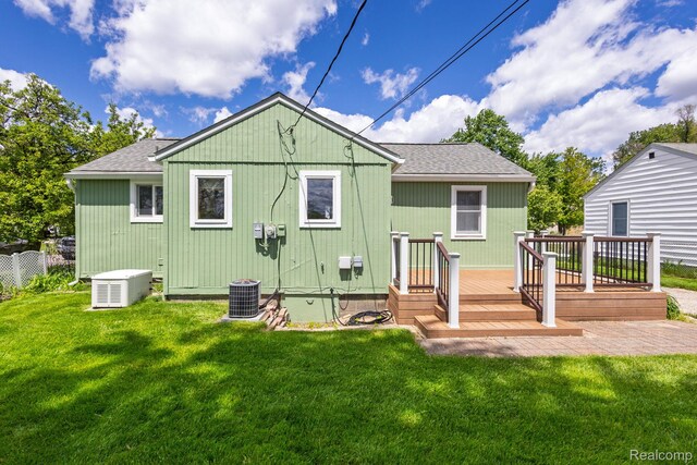 2500 Howe St, Shelby, MI 48317 - rear view of house featuring roof with shingles, a deck, cooling unit, and a lawn