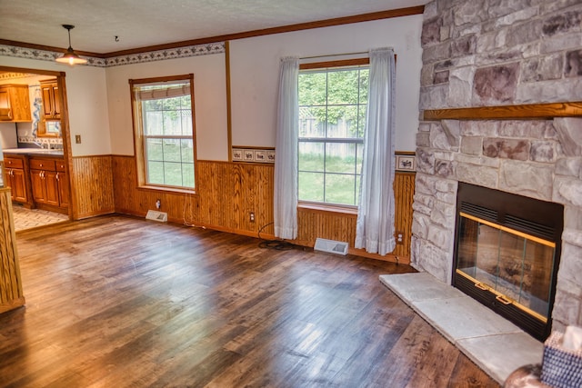 270 E Southern Rd, Coldwater, MI 49036 - unfurnished living room with wainscoting, wood finished floors, ornamental molding, a stone fireplace, and a textured ceiling