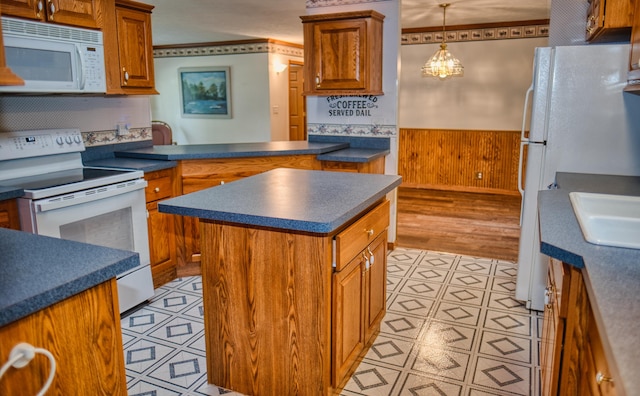 270 E Southern Rd, Coldwater, MI 49036 - kitchen featuring white appliances, dark countertops, brown cabinetry, a wainscoted wall, and crown molding