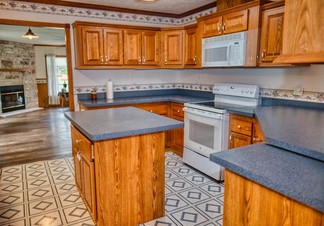 270 E Southern Rd, Coldwater, MI 49036 - kitchen featuring white appliances, dark countertops, brown cabinets, a center island, and light tile patterned floors