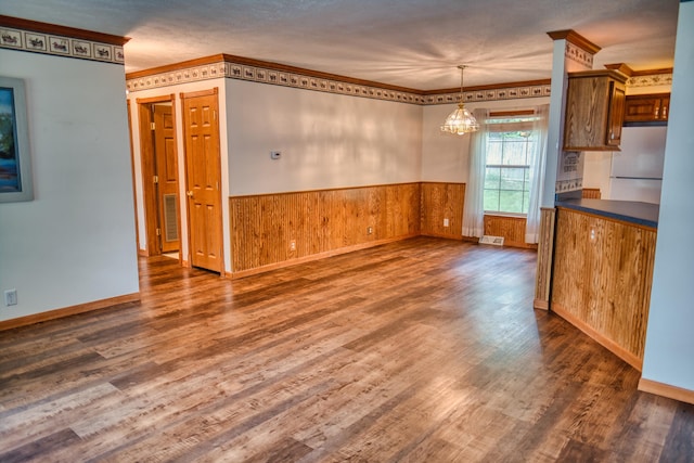 270 E Southern Rd, Coldwater, MI 49036 - unfurnished dining area with a chandelier, a wainscoted wall, dark wood-type flooring, wood walls, and ornamental molding