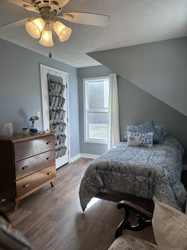 406 S Elm Ave, Jackson, MI 49203 - bedroom featuring wood finished floors, a textured ceiling, baseboards, and a ceiling fan