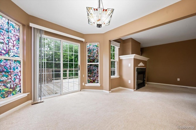 4632 Hunters Cir W, Canton, MI 48188 - unfurnished living room with carpet flooring, a chandelier, baseboards, and a glass covered fireplace
