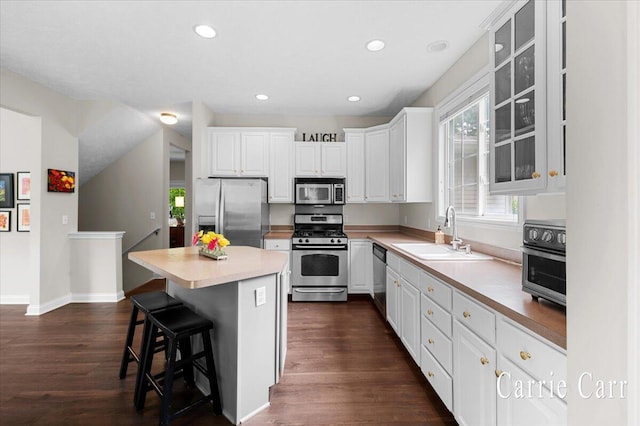 745 Abbey Mill Ct SE, Ada, MI 49301 - kitchen featuring stainless steel appliances, a sink, a breakfast bar area, white cabinets, and a kitchen island