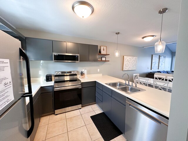 261 Black River St Unit F, South Haven, MI 49090 - kitchen with appliances with stainless steel finishes, a sink, light countertops, pendant lighting, and light tile patterned flooring