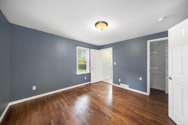 647 Church St, Grass Lake, MI 49240 - unfurnished bedroom featuring wood finished floors, baseboards, a walk in closet, and a closet