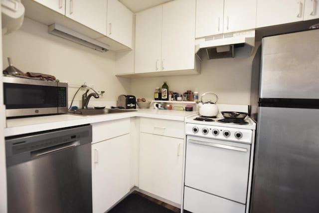 555 E William St Unit 21E, Ann Arbor, MI 48104 - kitchen with appliances with stainless steel finishes, under cabinet range hood, light countertops, and white cabinets