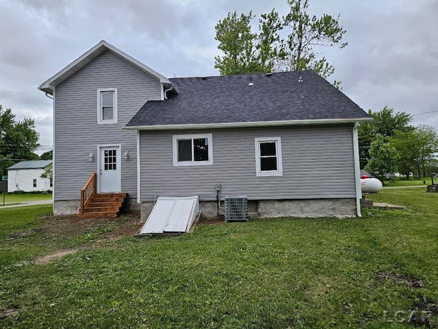 17045 Mill St, Hudson, MI 49247 - back of house featuring central AC, a lawn, entry steps, and a shingled roof