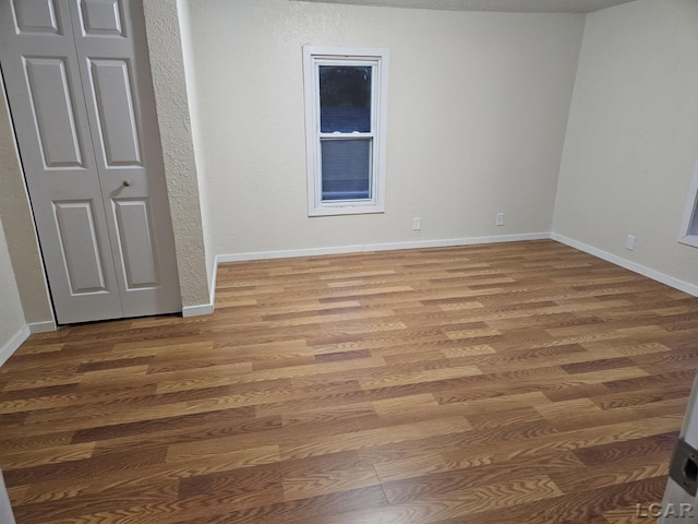 17045 Mill St, Hudson, MI 49247 - unfurnished bedroom featuring wood finished floors, baseboards, and a closet
