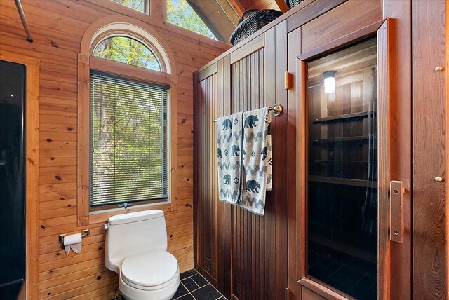 5765 Wildwood Dr, Bridgman, MI 49106 - bathroom featuring wood walls, toilet, vaulted ceiling, and tile patterned floors