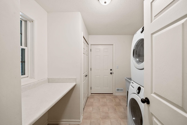 64711 Shorewood Ln, Cassopolis, MI 49031 - washroom with estacked washer and dryer, baseboards, and a textured ceiling