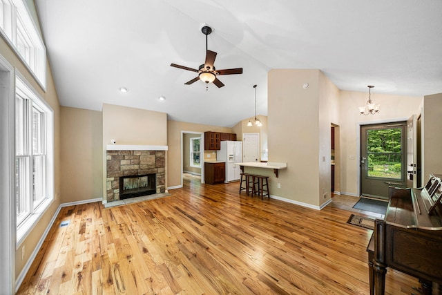 64711 Shorewood Ln, Cassopolis, MI 49031 - living area featuring light wood-style flooring, ceiling fan, a stone fireplace, baseboards, and high vaulted ceiling