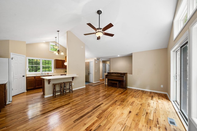 64711 Shorewood Ln, Cassopolis, MI 49031 - unfurnished living room featuring high vaulted ceiling, light wood-style flooring, a ceiling fan, baseboards, and a sink
