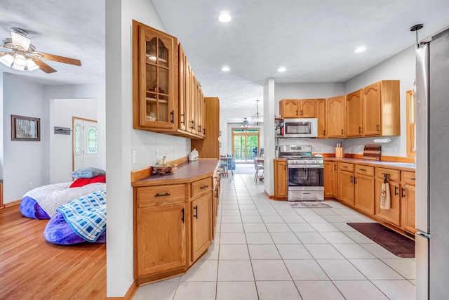 6248 Black Forest Trl, Muskegon, MI 49442 - kitchen with stainless steel appliances, ceiling fan, glass insert cabinets, recessed lighting, and a chandelier