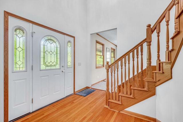 6248 Black Forest Trl, Muskegon, MI 49442 - entrance foyer with light wood-style floors, stairs, baseboards, and a towering ceiling