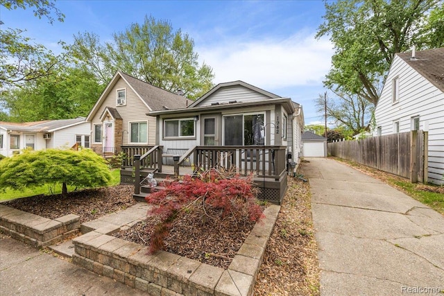 1942 E Troy St, Ferndale, MI 48220 - view of front of property featuring a wooden deck, a garage, an outdoor structure, and roof with shingles