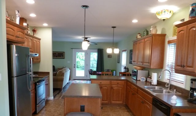 317 Monroe St, South Haven, MI 49090 - kitchen with appliances with stainless steel finishes, a sink, dark countertops, a ceiling fan, and a peninsula