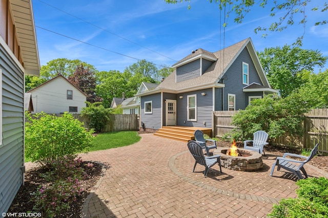 1310 Harrison Ave, Saint Joseph, MI 49085 - back of property featuring an outdoor fire pit, a fenced backyard, roof with shingles, and a patio area