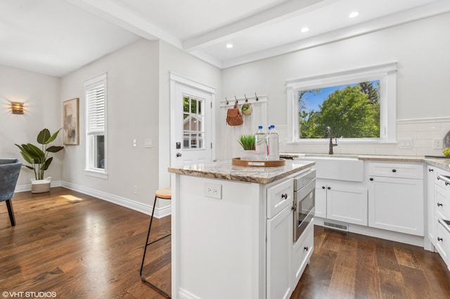 1310 Harrison Ave, Saint Joseph, MI 49085 - kitchen with healthy amount of natural light, a center island, decorative backsplash, beamed ceiling, and recessed lighting
