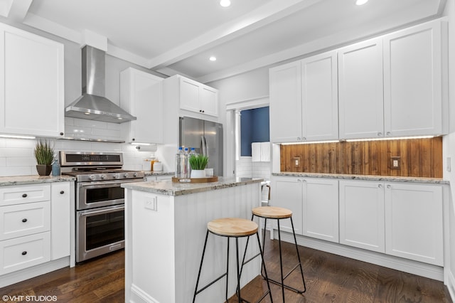 1310 Harrison Ave, Saint Joseph, MI 49085 - kitchen featuring wall chimney range hood, stainless steel appliances, dark wood-style floors, recessed lighting, and a center island