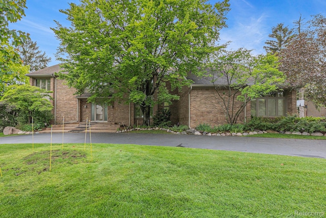3870 Glen Falls Dr, Bloomfield Hills, MI 48302 - view of property hidden behind natural elements with brick siding, a front lawn, and asphalt driveway