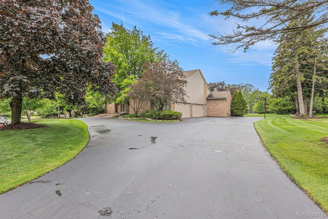 3870 Glen Falls Dr, Bloomfield Hills, MI 48302 - view of front of home with a garage, a front yard, and asphalt driveway