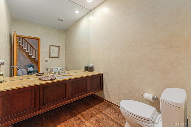 3870 Glen Falls Dr, Bloomfield Hills, MI 48302 - half bath featuring wood finished floors, toilet, vanity, ensuite bath, and recessed lighting