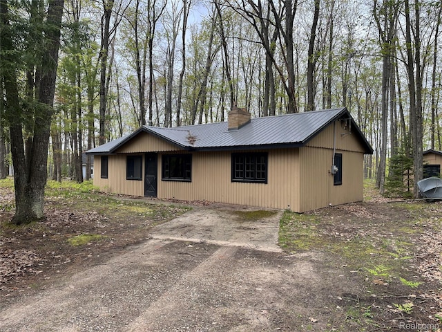 478 Karcher Rd, Rose City, MI 48654 - view of front of home featuring a chimney, dirt driveway, and metal roof