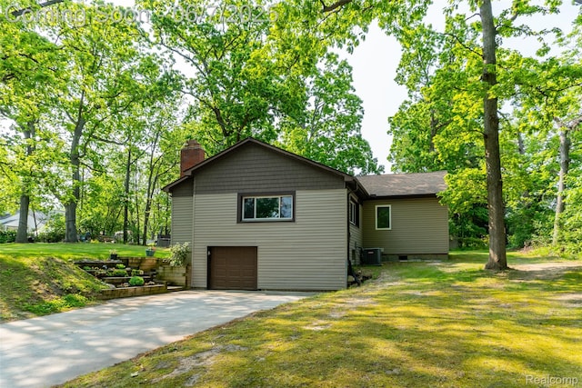 421 S Opdyke Rd, Auburn Hills, MI 48326 - view of property exterior with a chimney, driveway, a garage, a yard, and central AC