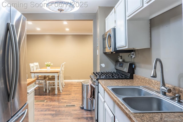 421 S Opdyke Rd, Auburn Hills, MI 48326 - kitchen with appliances with stainless steel finishes, a sink, wood finished floors, white cabinets, and recessed lighting
