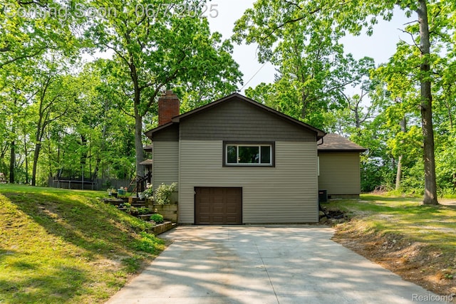 421 S Opdyke Rd, Auburn Hills, MI 48326 - view of side of property featuring a chimney, driveway, an attached garage, and a lawn