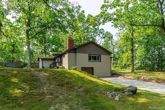 421 S Opdyke Rd, Auburn Hills, MI 48326 - view of home's exterior with a chimney, concrete driveway, and an attached garage
