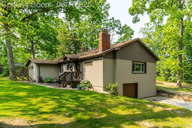 421 S Opdyke Rd, Auburn Hills, MI 48326 - view of home's exterior featuring a chimney, a yard, driveway, and an attached garage