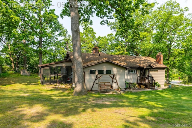 421 S Opdyke Rd, Auburn Hills, MI 48326 - back of property featuring a sunroom, a chimney, and a yard