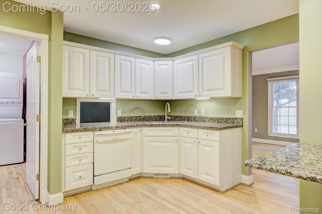 1660 Normandy Rd, Clawson, MI 48017 - kitchen with white dishwasher, stacked washer / dryer, light wood finished floors, a sink, and crown molding