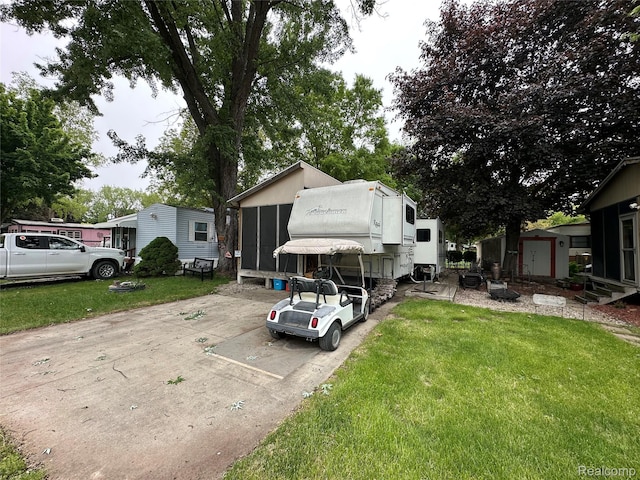 10001 Goodall Unit 77, Durand, MI 48429 - view of front of house featuring a sunroom and a front lawn