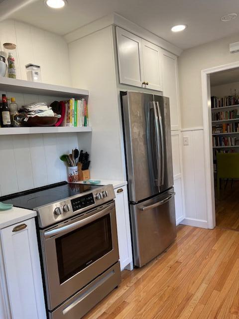 808 Princeton Ave, Ann Arbor, MI 48103 - kitchen featuring appliances with stainless steel finishes, light wood-type flooring, light countertops, a wainscoted wall, and white cabinetry