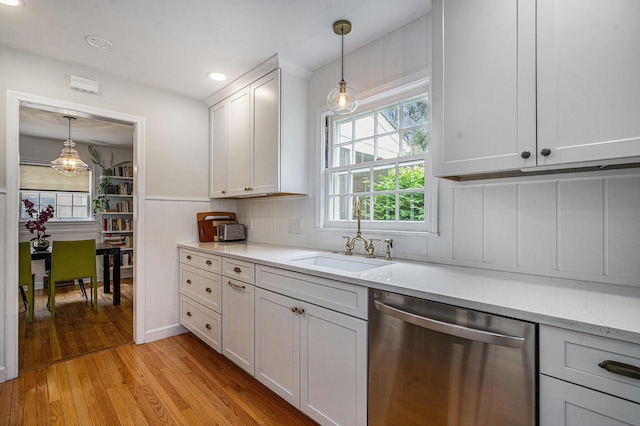 808 Princeton Ave, Ann Arbor, MI 48103 - kitchen featuring dishwasher, a sink, light wood finished floors, decorative light fixtures, and white cabinets