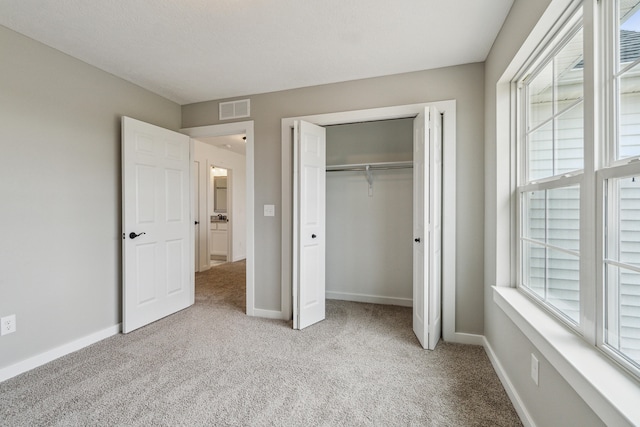 705 Montels Way, Charlotte, MI 48813 - unfurnished bedroom with carpet flooring, multiple windows, baseboards, and a closet
