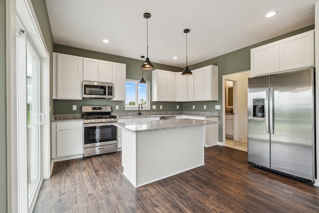 705 Montels Way, Charlotte, MI 48813 - kitchen with stainless steel appliances, dark wood finished floors, white cabinets, a kitchen island, and recessed lighting