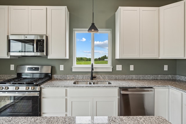705 Montels Way, Charlotte, MI 48813 - kitchen with appliances with stainless steel finishes, a sink, white cabinetry, and hanging light fixtures