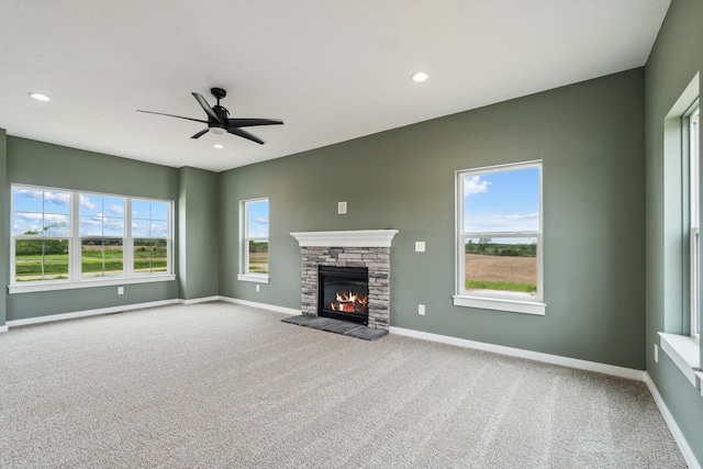 705 Montels Way, Charlotte, MI 48813 - unfurnished living room with carpet, a stone fireplace, baseboards, ceiling fan, and recessed lighting