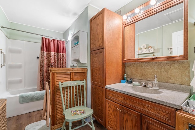 75 Taylor Ave, Battle Creek, MI 49037 - bathroom featuring wood finished floors, vanity, shower / bath combo with shower curtain, and decorative backsplash