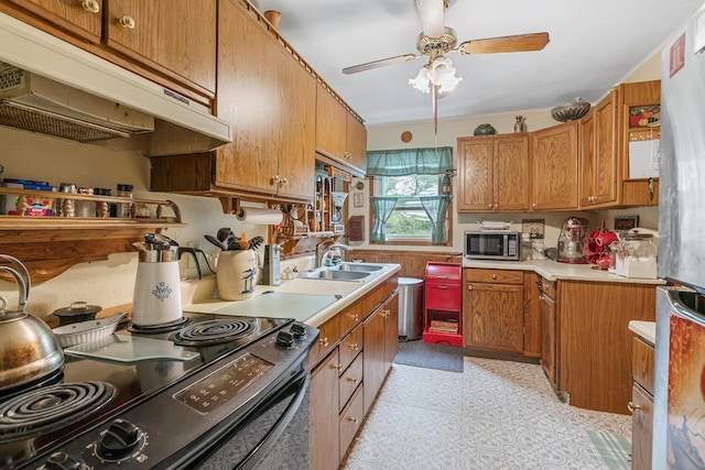 75 Taylor Ave, Battle Creek, MI 49037 - kitchen with stainless steel microwave, under cabinet range hood, a sink, black electric range, and light countertops