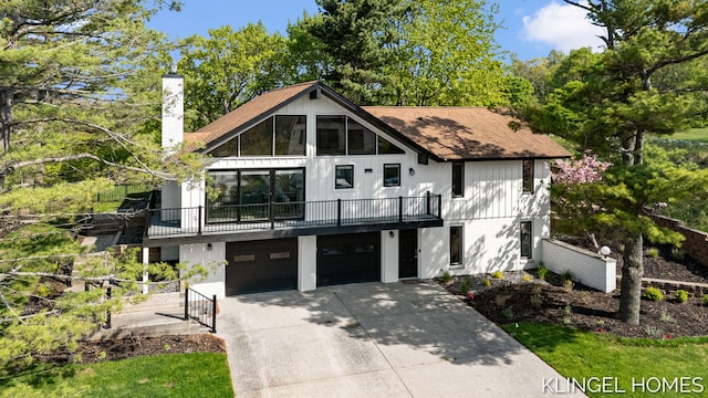 127 Emmet St, Grand Haven, MI 49417 - view of front of property featuring a chimney, concrete driveway, a garage, a balcony, and brick siding