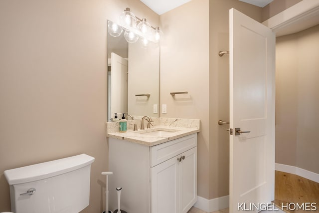 127 Emmet St, Grand Haven, MI 49417 - bathroom featuring toilet, vanity, and baseboards