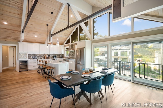 127 Emmet St, Grand Haven, MI 49417 - dining space with beverage cooler, high vaulted ceiling, wood ceiling with exposed beams, and light wood-style floors